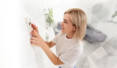 Woman Adjusting Thermostat